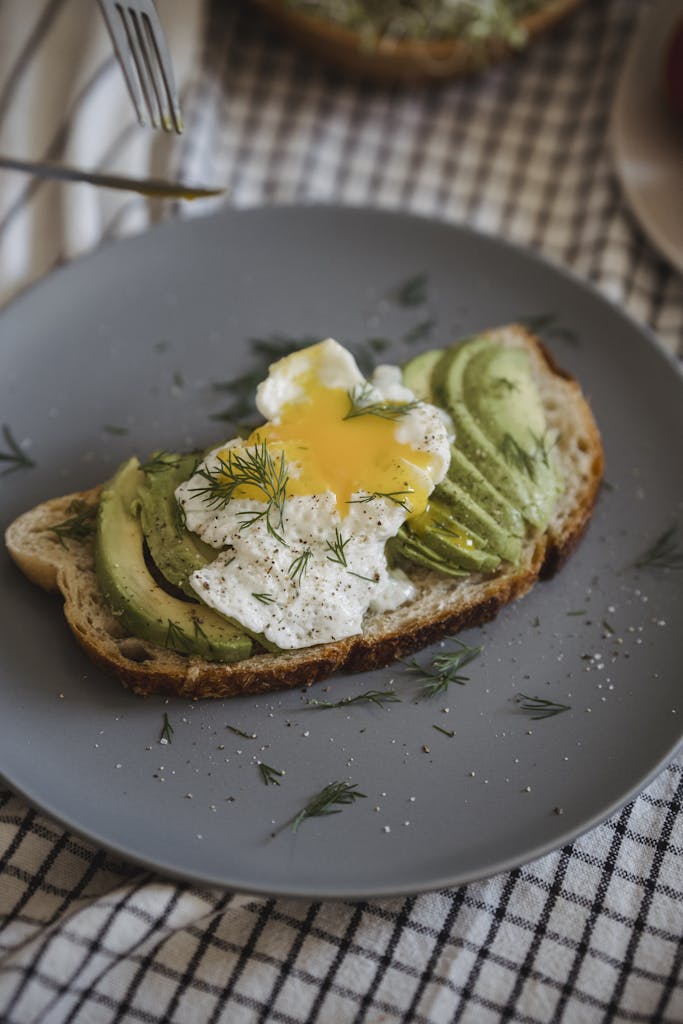Delicious avocado and poached egg served on a slice of rustic bread for breakfast.