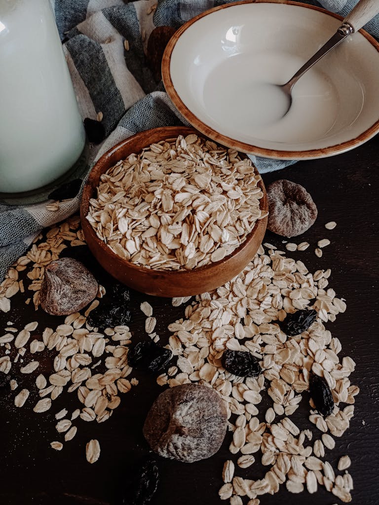 Warm-toned image of oats, dried figs, and a bowl of milk for a rustic breakfast setup.