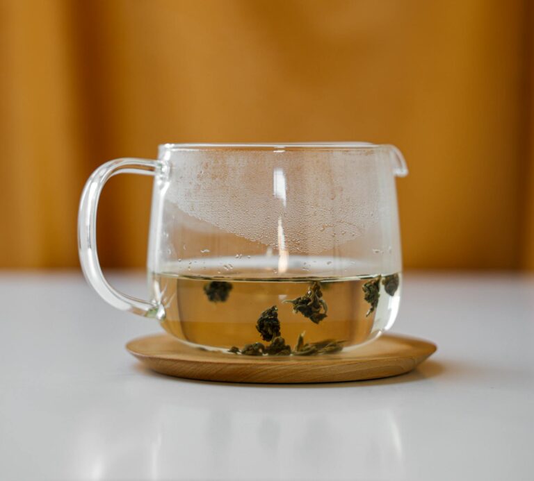 Serene still life of a glass teapot with herbal infusion. Perfect for detox themes.