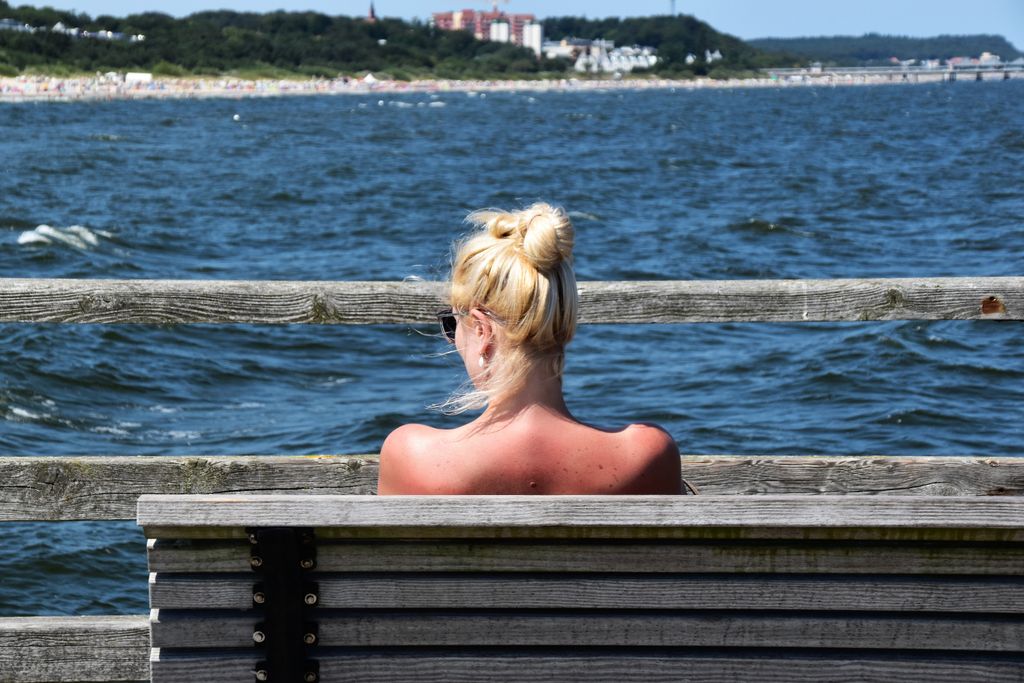 Relaxing moment by the sea in Heringsdorf, Germany, featuring a woman enjoying the peaceful seaside view.