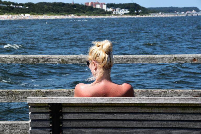 Relaxing moment by the sea in Heringsdorf, Germany, featuring a woman enjoying the peaceful seaside view.
