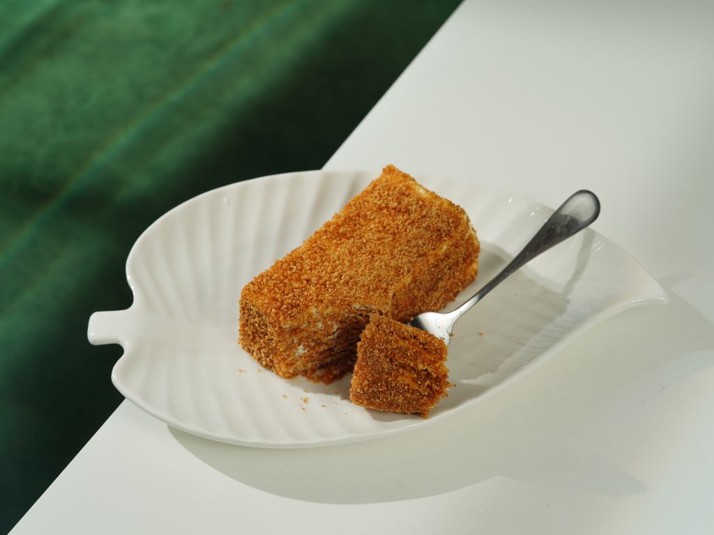 A close-up of a delicious crumb cake slice on a decorative plate, inviting and mouth-watering.