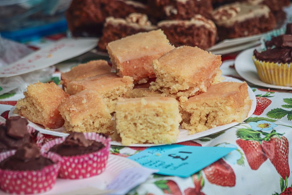Appetizing lemon squares and cupcakes elegantly displayed at a bakery or market stand.