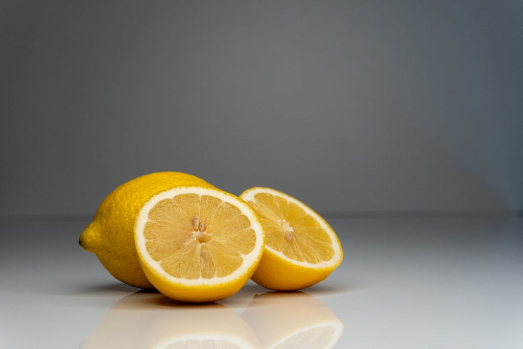 Vibrant yellow lemons sliced in half, showcasing fresh citrus in a studio setting.